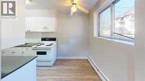 Grande Prairie apartment for rent - A kitchen with a stove top oven and a fan.