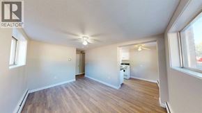 Grande Prairie apartment for rent - A spacious room with wooden flooring and a ceiling fan.