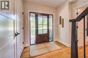 Kitchener apartment for rent - A hallway with a wooden door and a rug on the floor.