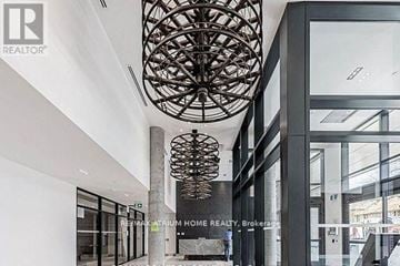 Toronto (South Riverdale) condo for rent - A modern interior space with a large, intricate chandelier hanging from the ceiling.