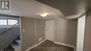 Oshawa (Central) apartment for rent - A room with a white door and a staircase with a wooden handrail.