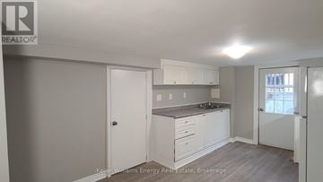 Oshawa (Central) apartment for rent - A kitchen with white cabinets and a grey countertop.