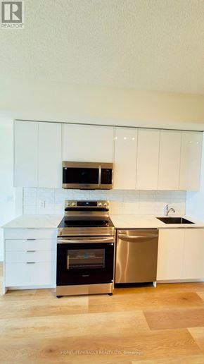 Brantford condo for rent - A modern kitchen with white cabinets and stainless steel appliances.
