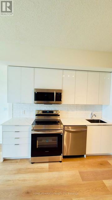 Brantford condo for rent - A modern kitchen with white cabinets and stainless steel appliances.