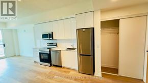 Brantford condo for rent - A kitchen with white cabinets and a stainless steel refrigerator.