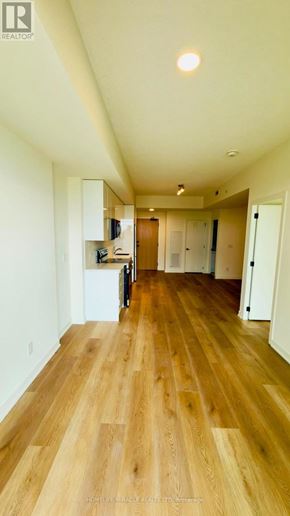 Brantford condo for rent - A long hallway with wood floors and white walls.