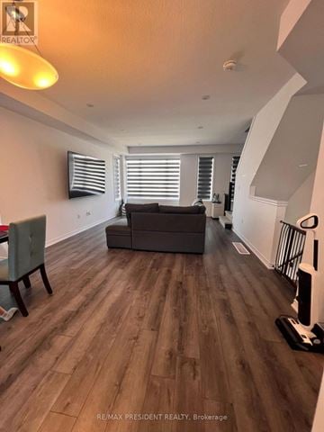 Hamilton (Stoney Creek Mountain) townhouse for rent - A living room with a grey couch and wooden flooring.