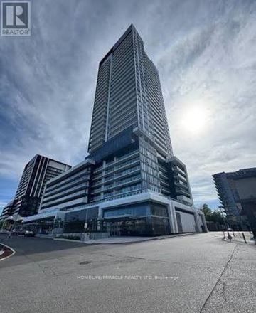 Toronto (Banbury-Don Mills) condo for rent - A tall, modern building with a glass facade is the focal point of the image.