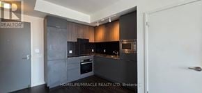Toronto (Banbury-Don Mills) condo for rent - A modern kitchen with dark wood cabinets and a white door.