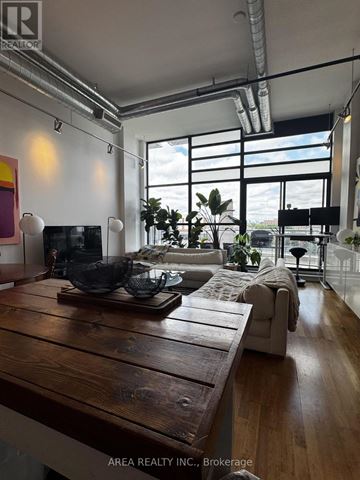 Toronto (Niagara) condo for rent - A modern living room with a wooden table and a large window.