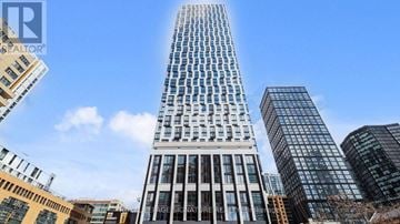 Toronto (Church-Yonge Corridor) condo for rent - A tall building with many windows stands in front of other buildings.