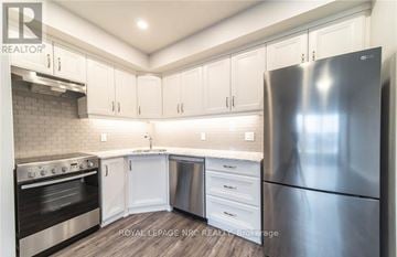 Niagara Falls (Hospital) condo for rent - A kitchen with white cabinets and a stainless steel refrigerator.