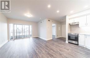 Niagara Falls (Hospital) condo for rent - A spacious living room with wood flooring and a kitchen area in the background.
