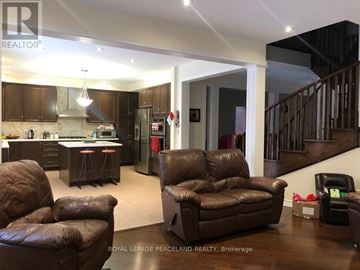 Aurora apartment for rent - A living room with brown leather furniture and a staircase.