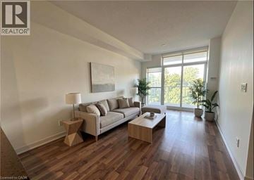 Burlington condo for rent - A living room with a couch, a table, and a painting on the wall.