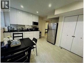 Vancouver apartment for rent - A kitchen with a black table and chairs and a refrigerator.