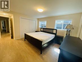 Vancouver apartment for rent - A bedroom with a bed, dresser, and window.