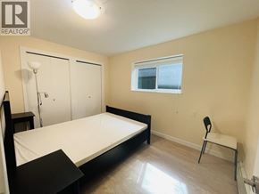 Vancouver apartment for rent - A bedroom with a bed, chair, and a window.