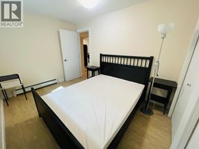 Vancouver apartment for rent - A bedroom with a bed, chair, and lamp.