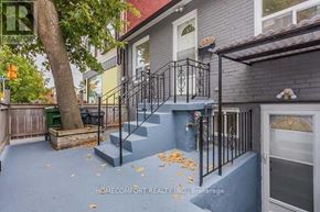 Toronto (Trinity-Bellwoods) apartment for rent - A house with a grey front yard and a tree.