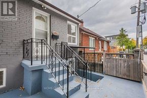 Toronto (Trinity-Bellwoods) apartment for rent - A house with a grey front and a black railing on the stairs.