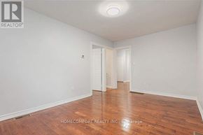 Toronto (Trinity-Bellwoods) apartment for rent - A room with wooden flooring and white walls, with a door on the left and another door on the right.