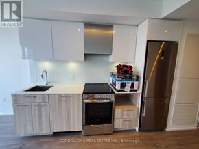 Toronto (Moss Park) condo for rent - A kitchen with white cabinets and a stainless steel refrigerator.
