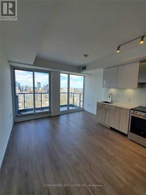 Toronto (Moss Park) condo for rent - A spacious kitchen with wood flooring and a large window overlooking the city.