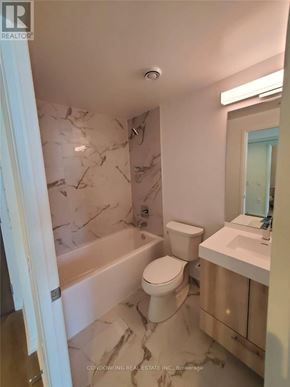 Toronto (Moss Park) condo for rent - A white bathroom with marble tiles on the walls.