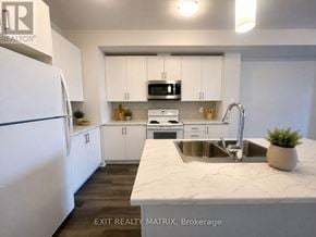Russell townhouse for rent - A kitchen with white cabinets and a marble countertop.