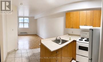 Toronto (Church-Yonge Corridor) condo for rent - A kitchen with wooden cabinets and a white stove top oven.