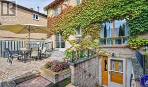 Pickering (Amberlea) apartment for rent - A patio with a table and chairs is surrounded by a wall covered in green vines.