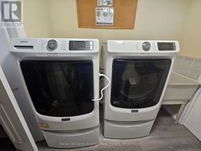 Toronto (Bendale) apartment for rent - Two white ovens are in a room with a brown board on the wall.