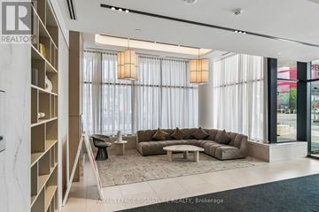 Toronto (Regent Park) condo for rent - A modern living room with a large sectional sofa and a built-in bookshelf.
