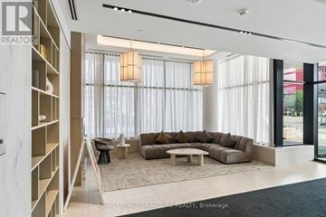 Toronto (Regent Park) condo for rent - A modern living room with a large sectional sofa and a built-in bookshelf.