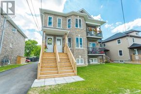 Cornwall triplex for rent - A two-story house with a front porch and a garage.