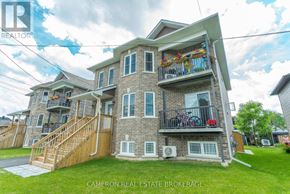 Cornwall triplex for rent - A two-story house with a balcony and a bicycle parked on it.