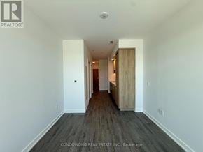Vaughan (Vaughan Corporate Centre) condo for rent - A long hallway with wood floors and white walls.