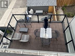 Toronto (University) apartment for rent - A patio with a table and chairs is surrounded by a black railing.