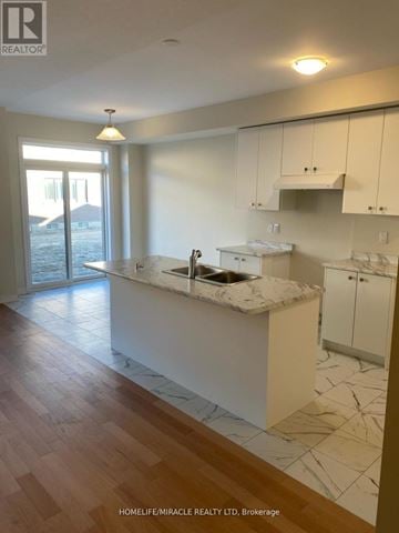 Thorold (Rolling Meadows) townhouse for rent - A kitchen with white cabinets and a marble countertop.