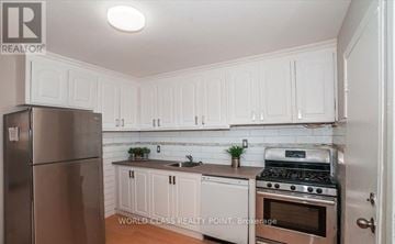 Toronto (Birchcliffe-Cliffside) apartment for rent - A kitchen with white cabinets and stainless steel appliances.
