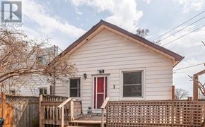 Toronto (Birchcliffe-Cliffside) apartment for rent - A small white house with a red door and a wooden fence.