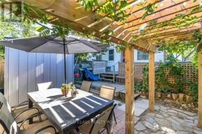 Toronto (Birchcliffe-Cliffside) apartment for rent - A patio with a table and chairs under a wooden pergola.