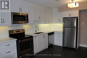 Mississauga (Port Credit) multi-family for rent - A kitchen with white cabinets and a stainless steel refrigerator.