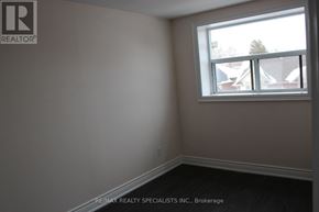 Mississauga (Port Credit) multi-family for rent - A room with a window and a view of a tree and houses outside.