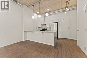 Windsor apartment for rent - A spacious room with a kitchenette and wooden flooring.