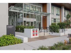 Surrey apartment for rent - The image shows a modern building with a glass facade and a sign that reads "UN INTERNATIONAL DISTRICT".