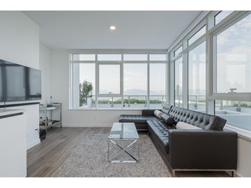 Surrey apartment for rent - A modern living room with a black sofa and a glass table.