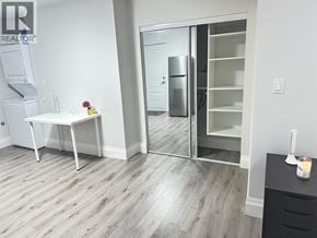 Vancouver apartment for rent - A kitchen area with a fridge, table, and a cabinet.