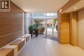 Vancouver apartment for rent - A hallway with a wooden floor and a glass door leading outside.